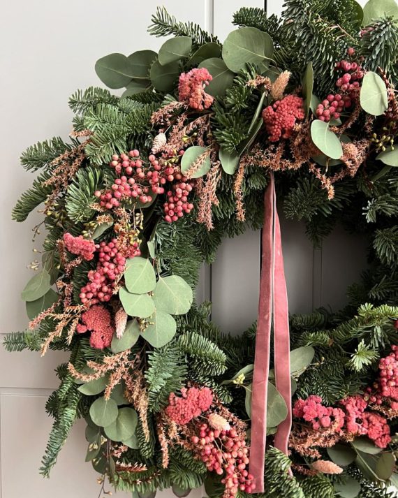 Detalle de corona navideña con tatarica rosada, achilea y pimienta seca