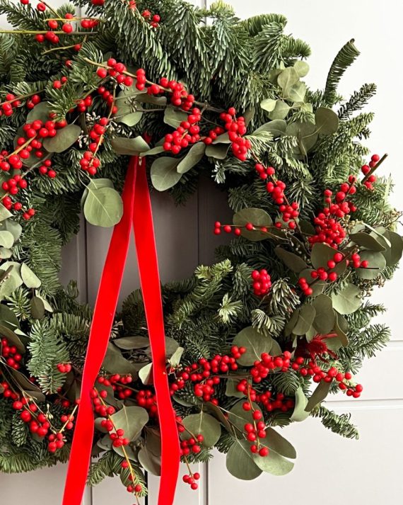 De talle navideño de Illes rojo y lazo en corona artesanal